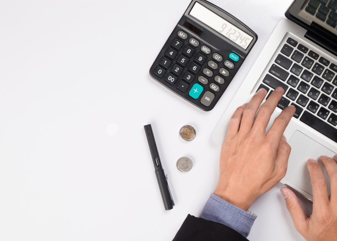 Businessman with laptop and the calculator counting the cash flow