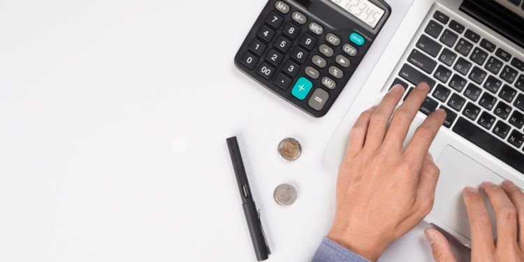 Businessman with laptop and the calculator counting the cash flow 