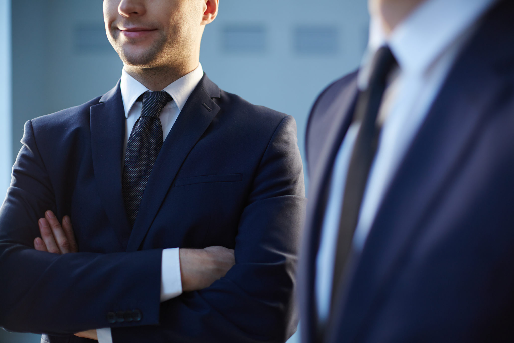 two man in the black suits standing in the office deciding about which software to choose for the small company 