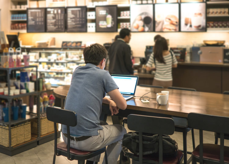 Work At A Coffee Shop With An Independent Laptop That Connects To The Internet Through Light. Computer