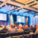 Blured Conference Room With A Person Presenting To The Audience