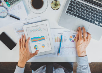 Businessman working with laptop computer and digital tablet and smart phone and document on wooden desk in office