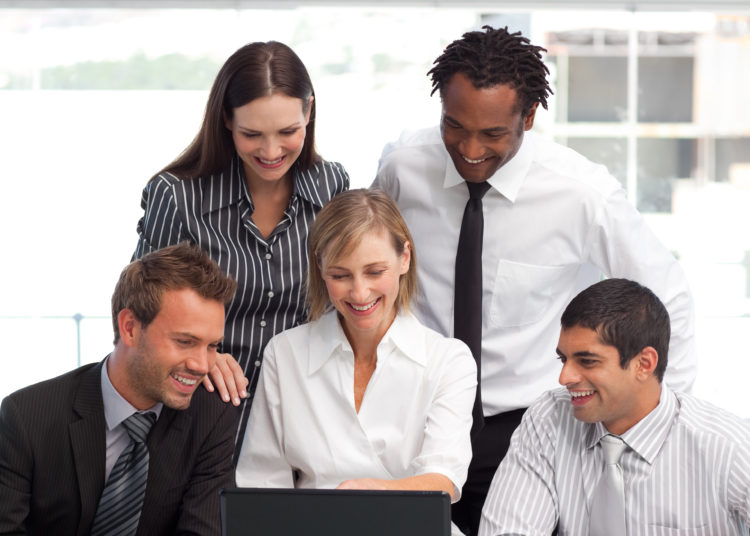 Businessteam working together with a laptop in office