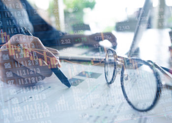 Double exposure of Stock chart and business woman working at the office. analysis document and using laptop.