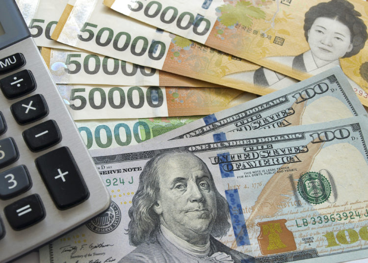 US one hundred dollar and Korean won currency with calculator. Finance business concept.