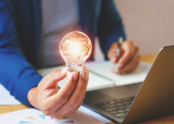 A businessman holding a light bulb in the office