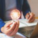 A businessman holding a light bulb in the office