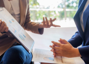 Business people discussing the charts and graphs showing the results of their successful teamwork.