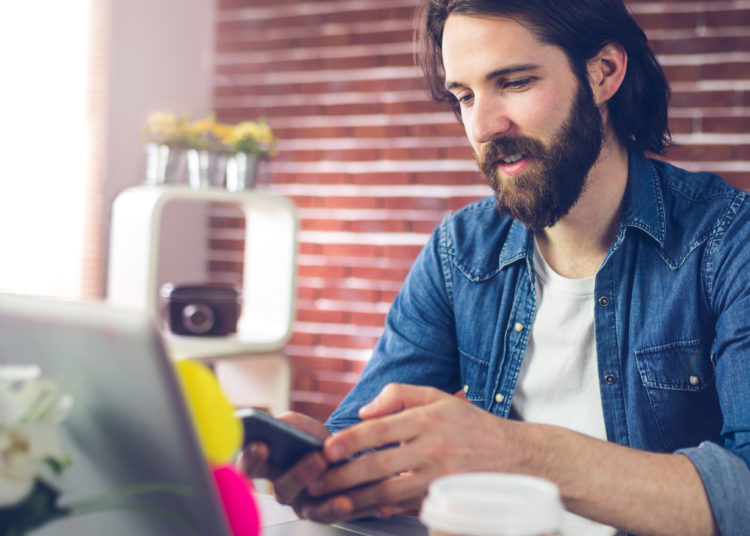 Creative businessman using mobile phone in office