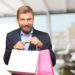 blond businessman with promotional bags