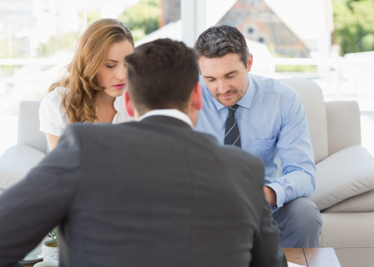 Young couple in meeting with a financial adviser in the living room at home