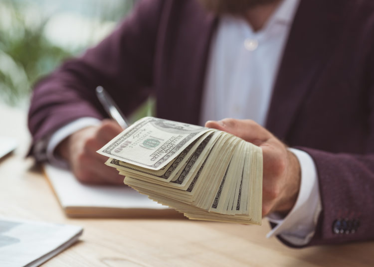 cropped view of businessman giving dollar banknotes, salary concept