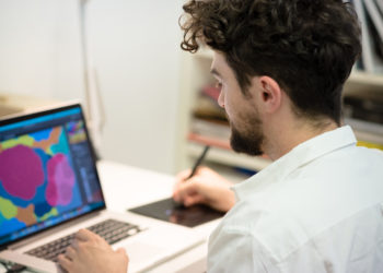 handsome hipster modern man designer working home using laptop at home