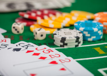 Poker chips on table in casino. Cards on green felt casino table
