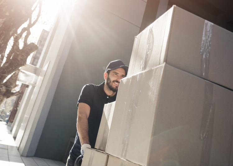 Delivery man unloading cardboard boxes