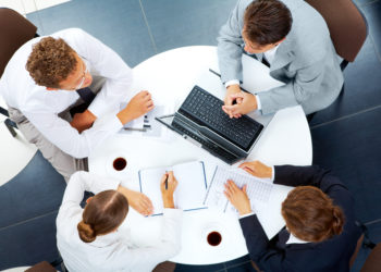 Above view of several business people planning work at round table