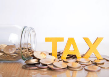 TAX Concept.Word tax put on coins and glass bottles with coins inside on white background.