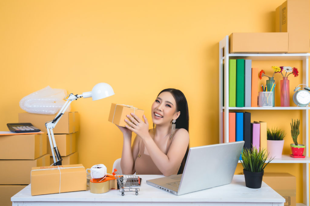 business owner working at home office packaging on background.