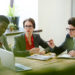 Financial managers looking at online data while discussing new project