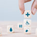 Hand chooses a emoticon icons healthcare medical symbol on wooden block , Healthcare and medical Insurance concept