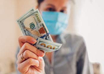 Coronavirus covid-19 pandemic pharmacy profit on medical masks. High prices for medicine. Woman holding dollars cash. Speculation