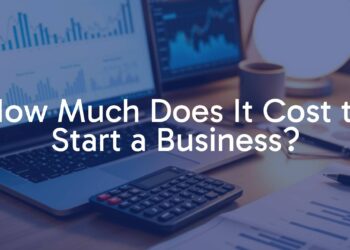 A modern business startup setup with a laptop, calculator, and financial charts on a desk, warm lighting, realistic.