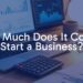 A modern business startup setup with a laptop, calculator, and financial charts on a desk, warm lighting, realistic.