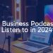 Modern podcast studio setup with a microphone, headphones, and a laptop showing business charts, vibrant and professional lighting, sleek and minimalist design.